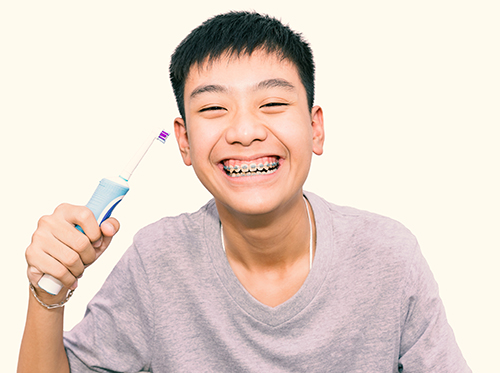 Boy with orthodontics holding a toothbrush